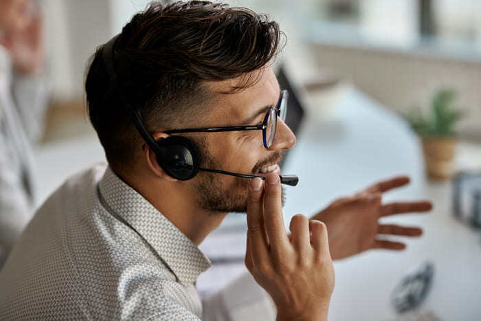 happy-call-center-agent-wearing-headset-while-talking-with-clients-working-office (1) (1)